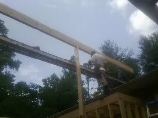 Carpenter setting a ridge beam over a new addition frame — Ice Dam Removal by Roofing Brothers in Ralph