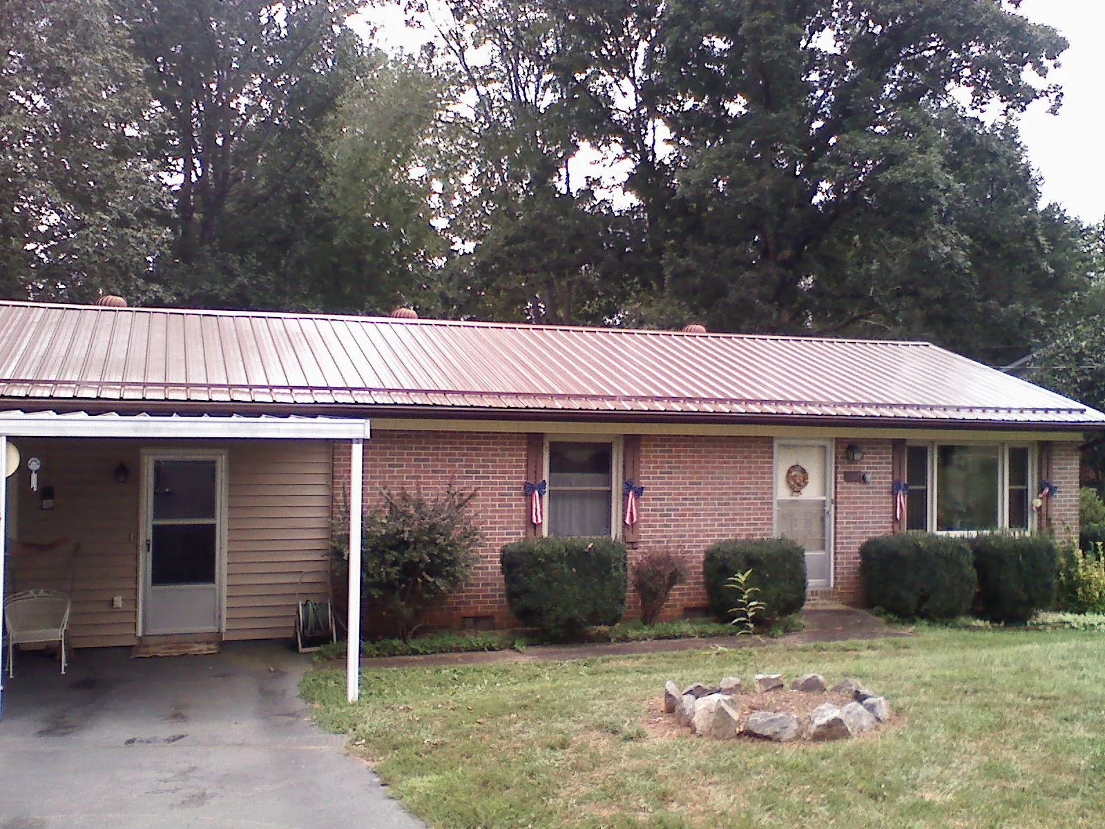 Bronze metal roof and carport on a brick ranch home — Roof Repair work by our crew in Ralph